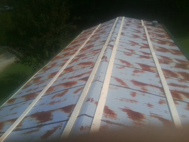 Rusted metal roof panels with new wood purlins before replacement — Storm Damage Roof Repair in Barboursville by Roofing Brothers