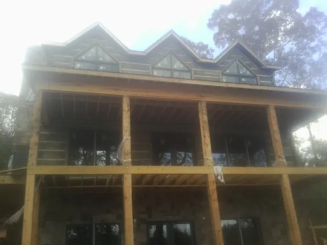 Dormers and porch framing on a large log home under construction — Roof Coating work by our crew in Barboursville