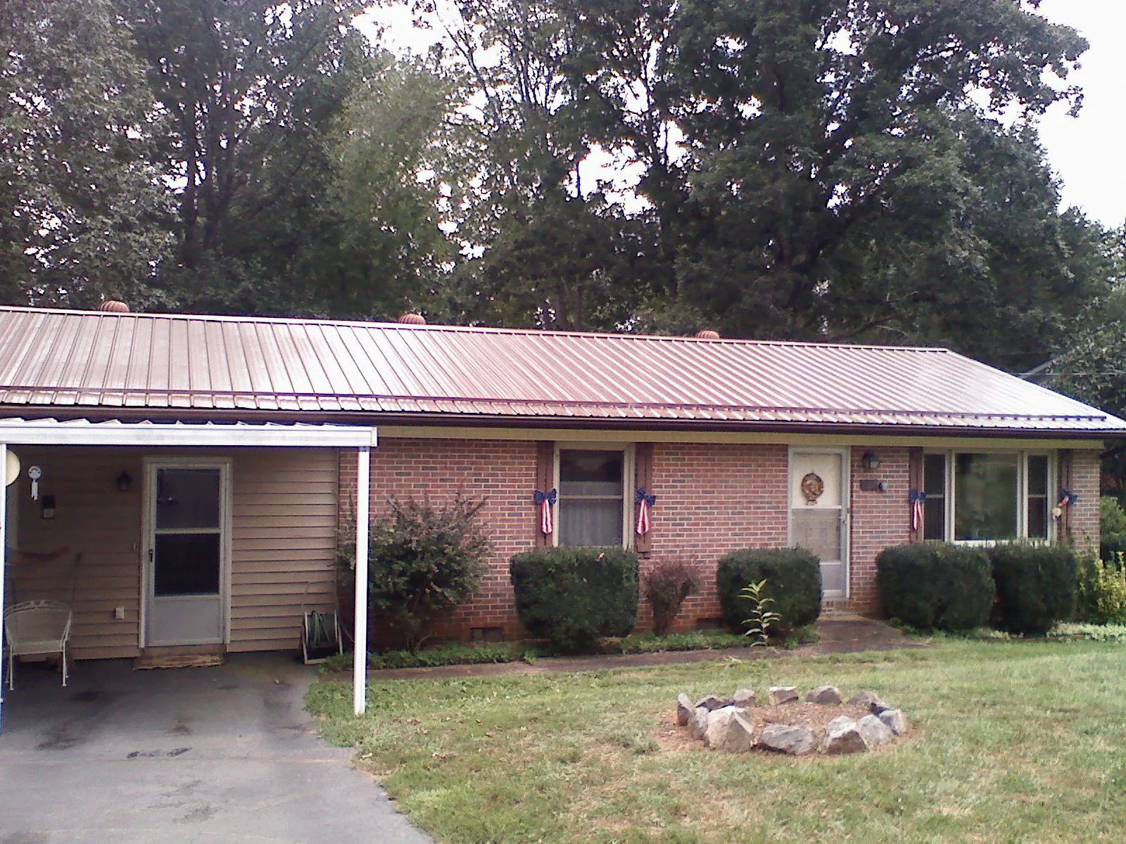 Bronze metal roof and carport on a brick ranch home — Roof Repair work by our crew in Barboursville